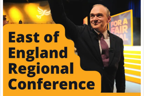 A photograph of Ed Davey MP, a white man in suit and tie, with the text East of England Regional Conference written on an orange background.